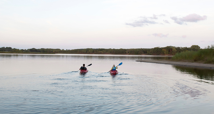 two individuals paddling on a lake